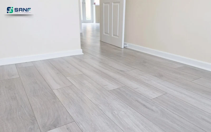 Lối vào lát sàn nhựa giả gỗ trắng xám với cửa trắng và chân tường trắng