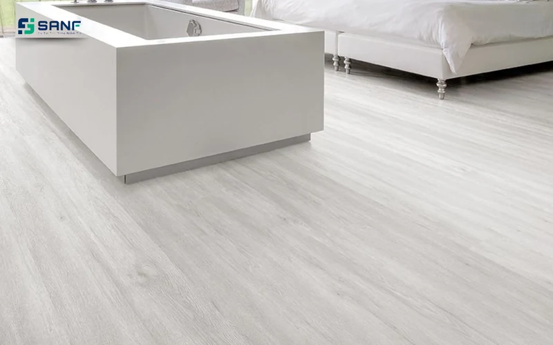 Sàn nhựa giả gỗ trắng xám bóng nhẹ cạnh khối bệ trắng và chân giường