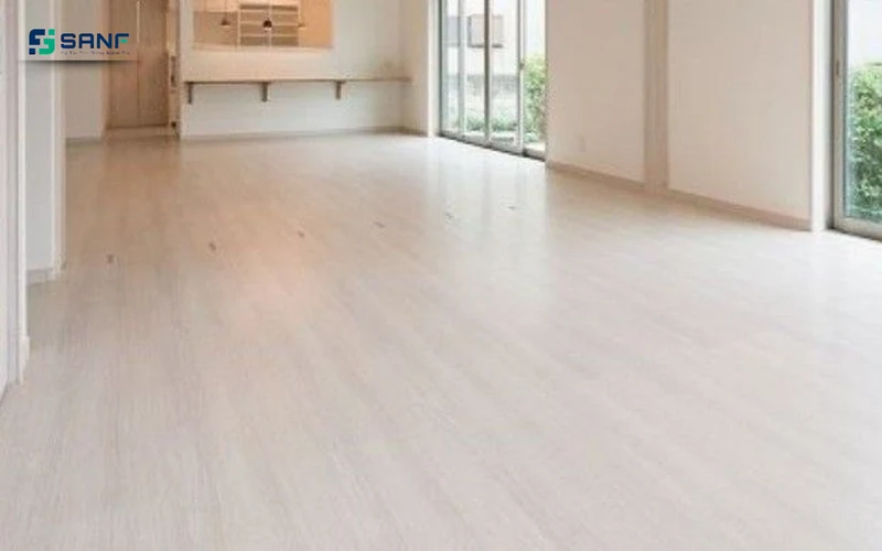 Căn phòng sáng lát sàn nhựa giả gỗ trắng sữa bên cửa kính lớn