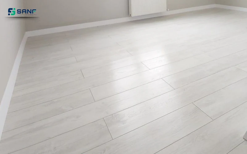 Phòng trống lát sàn nhựa giả gỗ trắng sữa bề mặt bóng nhẹ cạnh chân tường trắng