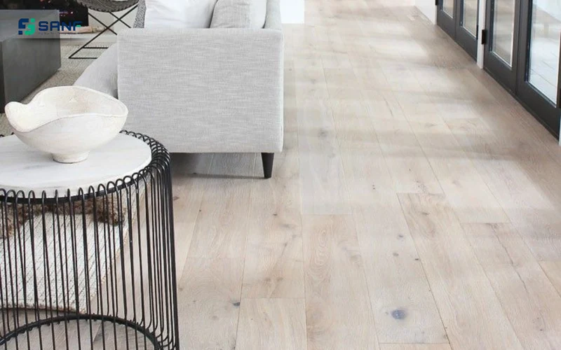 Sàn nhựa giả gỗ trắng bạch dương có mắt gỗ cạnh sofa xám và bàn phụ khung sắt
