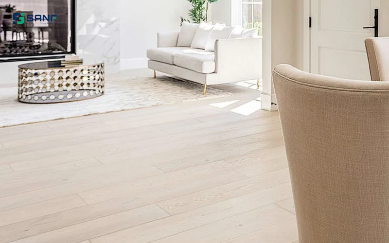 Phòng khách lát sàn nhựa giả gỗ trắng bạch dương cạnh sofa trắng và bàn trà khung kim loại