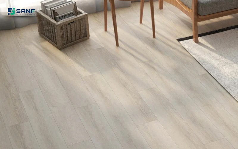 Sàn nhựa giả gỗ trắng gạo cạnh giỏ mây chân ghế gỗ và thảm sáng màu