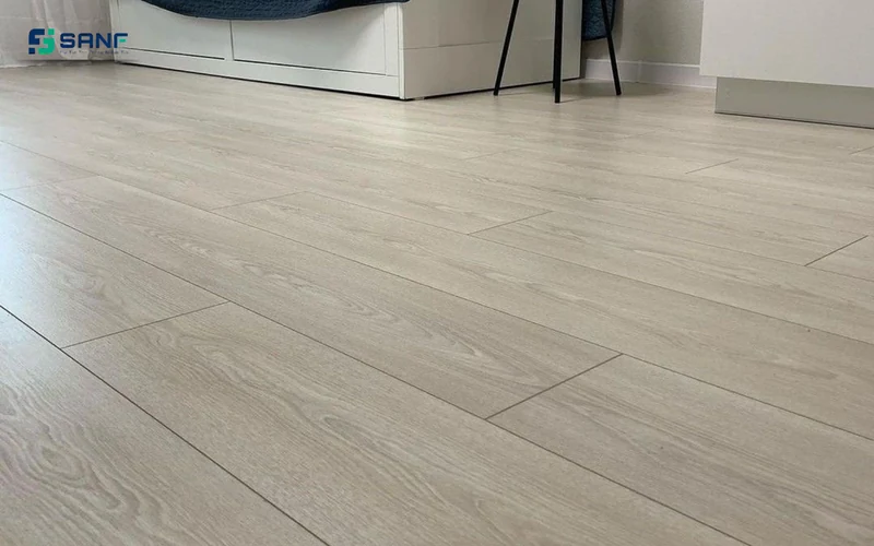 Sàn nhựa giả gỗ trắng gạo vân sồi trước tủ ngăn kéo trắng và chân ghế đen