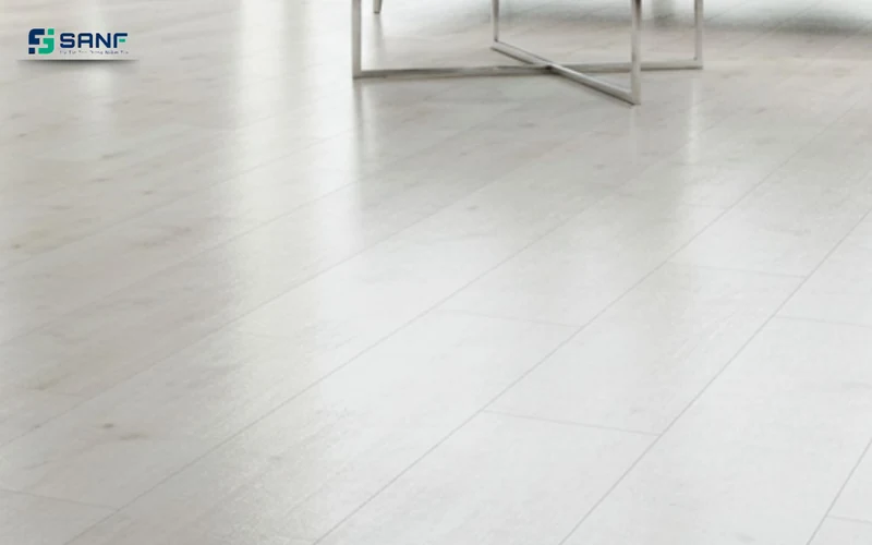 Sàn nhựa giả gỗ trắng sữa phản chiếu ánh sáng bên chân bàn khung kim loại